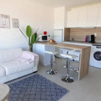 Vue de la cuisine équipée, de la machine à laver et du canapé-lit de l'appartement Face à la Mer