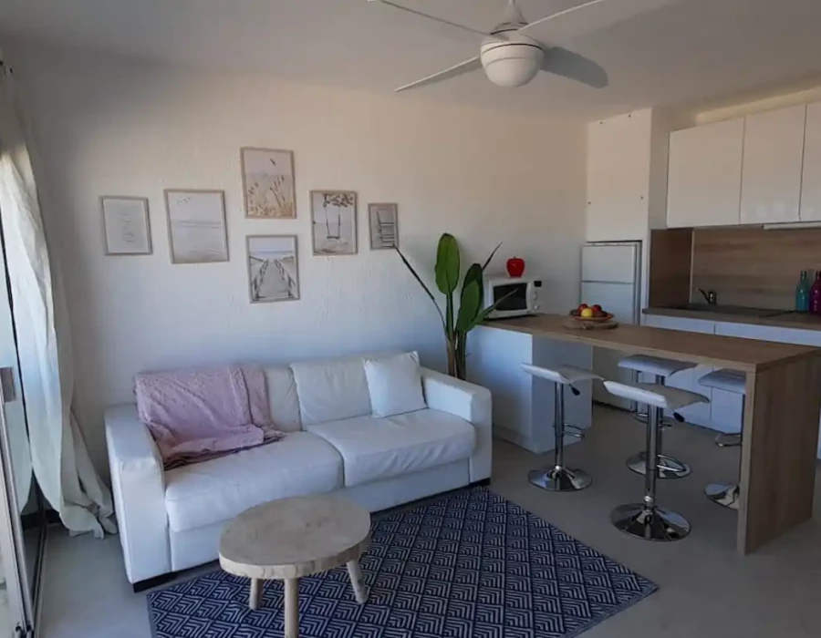 Vue de la cuisine équipée, de la machine à laver et du canapé-lit de l'appartement Face à la Mer
